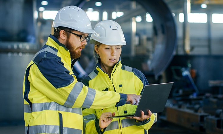 two aerospace engineer discussion wearing safety equipment