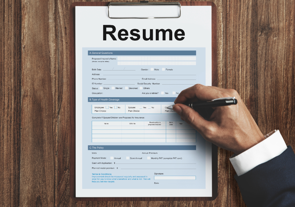 An image of resume format with a close of hand holding a pen ticking boxes on the resume format